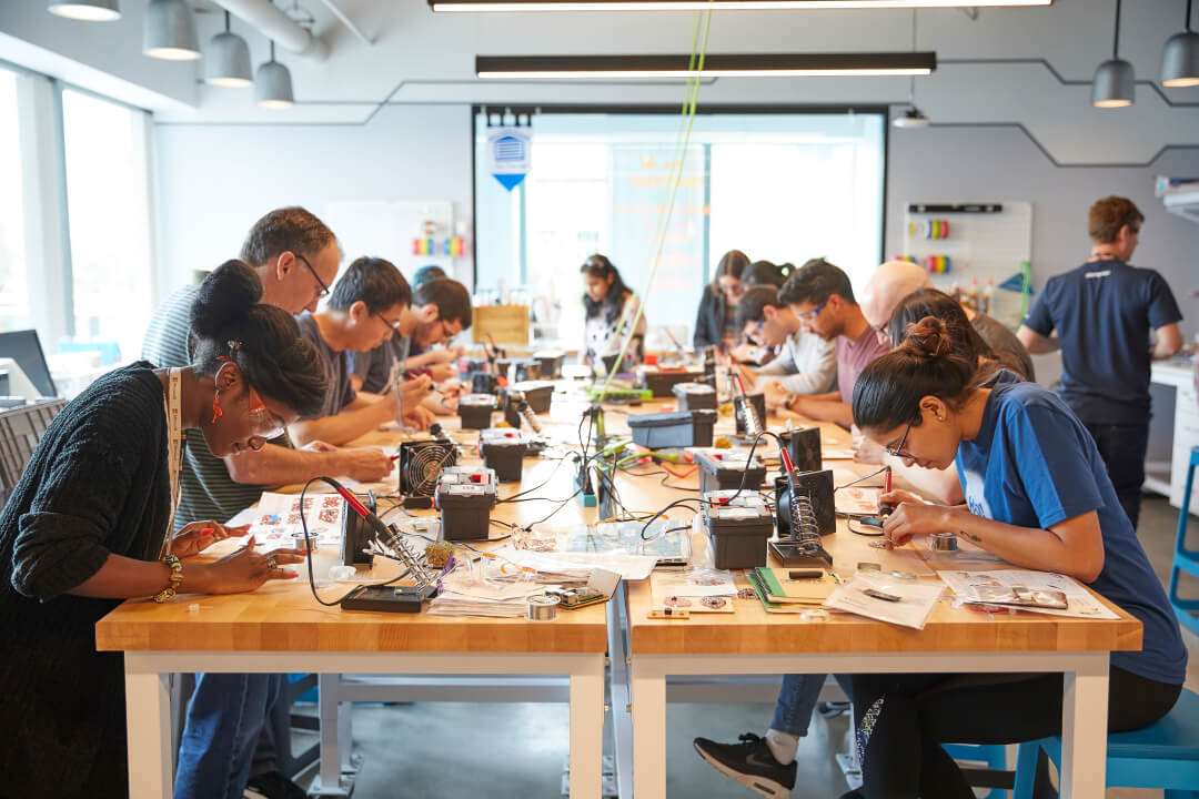People around a table working on a hands-on workshop project in The Garage