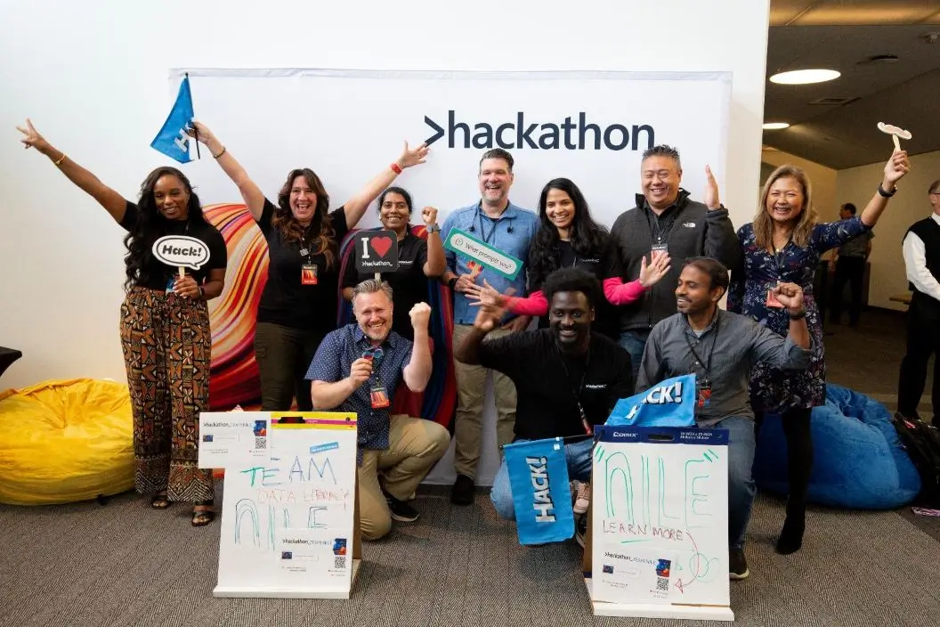 A Hackathon team cheering with their arms raised in celebration