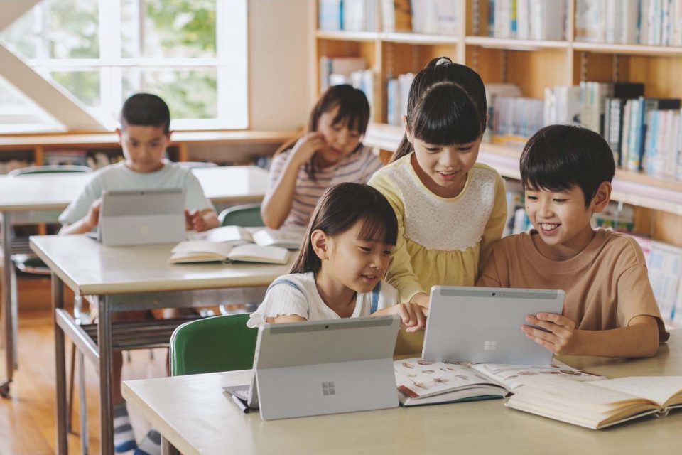 α 世代孩童一起使用平板電腦學習的照片